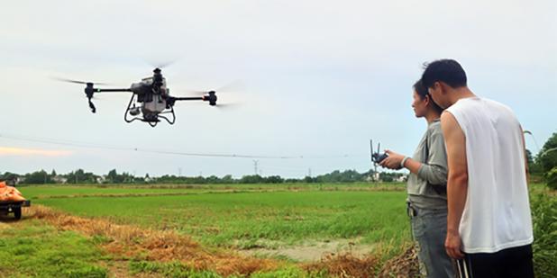 Learning to use drones in agriculture. Photo shows student and teacher in the countryside near Wuhu city, Anhui province.